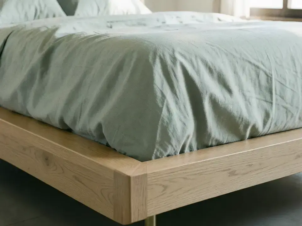 低いナラ材プラットフォームベッドとシャフェリネンのリネン寝具